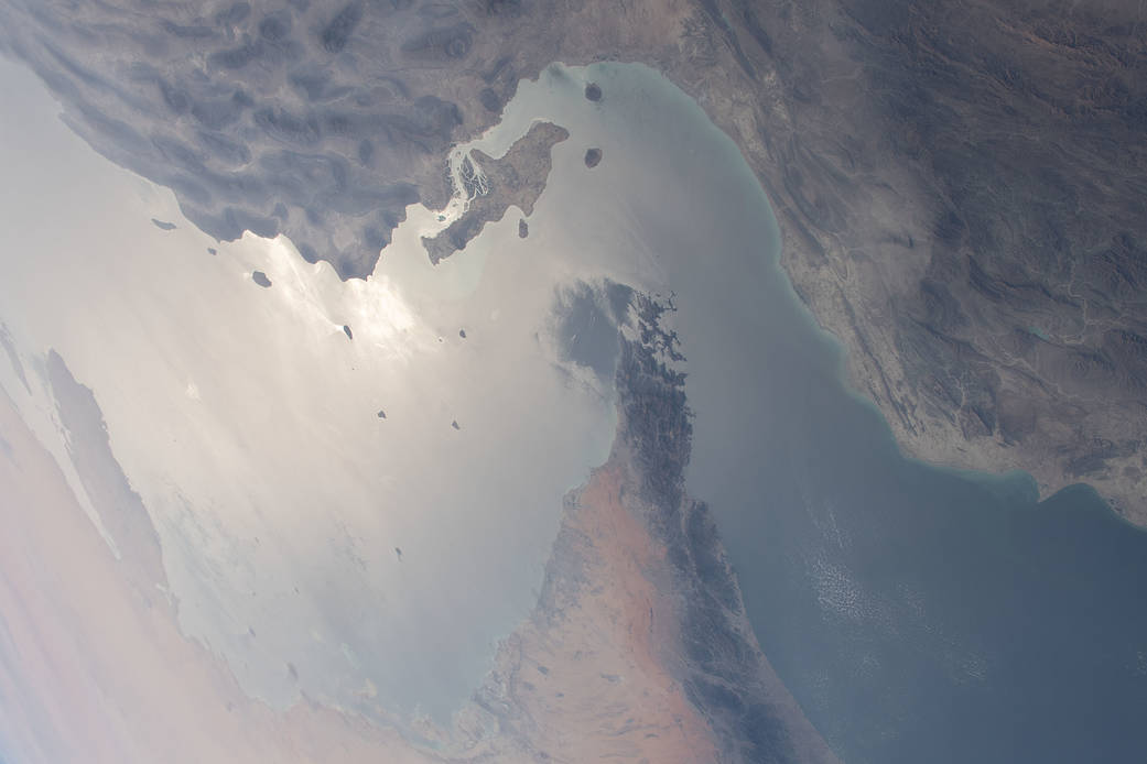 Photo prise depuis l'espace du détroit d'Hormuz : la côte iranienne en haut et ses îles, la péninsule du Musandam qui s'avance au centre, les Émirats en bas à gauche et le golfe d'Oman à droite.